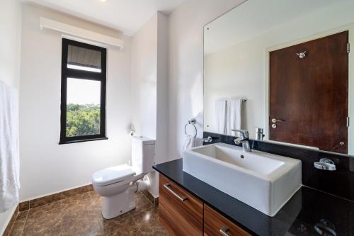 a bathroom with a white sink and a toilet at Ol Pejeta Mansion in Nanyuki