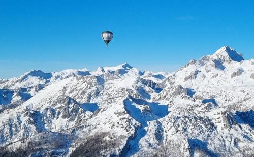 a hot air balloon flying over a snow covered mountain at Aparthouse Jana Breg in Žirovnica