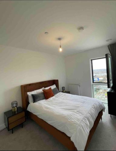 Un dormitorio con una cama grande y una ventana en Modern New Airy 1 Bed Apartment LONDON cosy stays en Barking