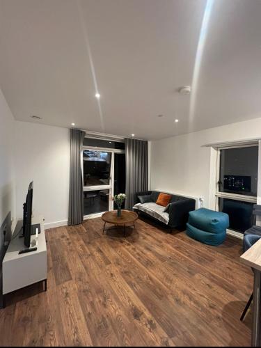 sala de estar con sofá y TV en Modern New Airy 1 Bed Apartment LONDON cosy stays en Barking