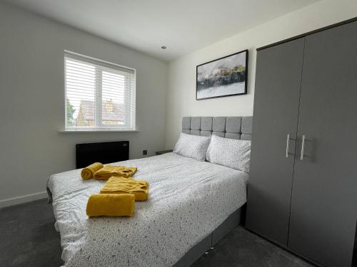 a bedroom with a bed with a yellow blanket on it at Stylish and Modern 2BR Apartment with Parking in Sheffield