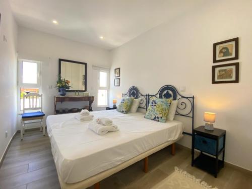 a bedroom with a large bed with towels on it at Armação de Pêra Ocean Breeze by Homing in Armação de Pêra