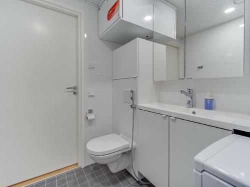 a white bathroom with a toilet and a sink at SPOT Apartments - Turun satama in Turku