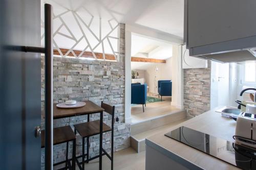 une cuisine avec une table et un mur en briques dans l'établissement #49 Perfect location Saleya old town 2mins to Sea AC, à Nice