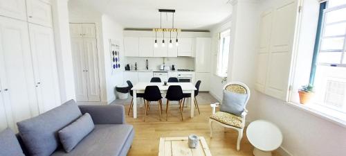 a living room with a couch and a table and chairs at Figueira Penthouse by the Marina in Figueira da Foz