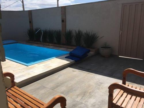 a patio with a pool and a bench at Chalé vista da serra in Delfinópolis