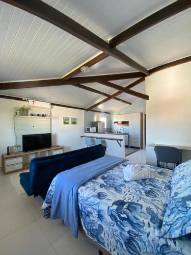 sypialnia z niebieskim łóżkiem i kuchnią w obiekcie Loft Studio - MAR AZUL w mieście Lauro de Freitas