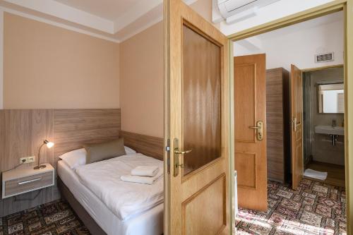 a small bedroom with a bed and a bathroom at Sport-V-Hotel in Hrotovice