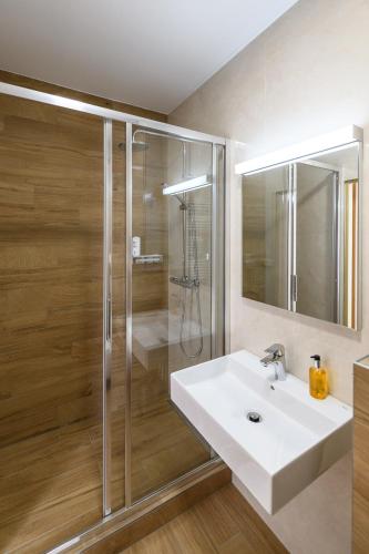 a bathroom with a white sink and a shower at Sport-V-Hotel in Hrotovice