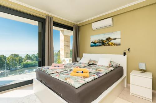 a bedroom with a bed and a large window at Club Panorama Lake View Apartment in Alsóörs