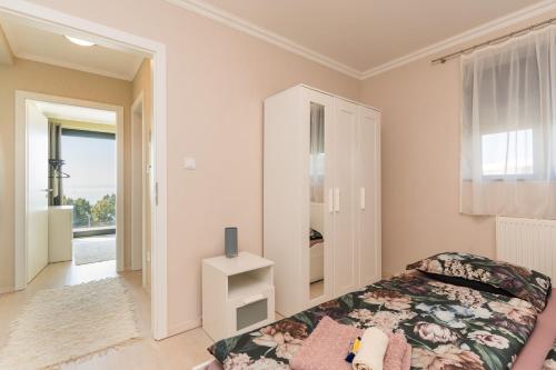 a bedroom with a bed and a window at Club Panorama Lake View Apartment in Alsóörs
