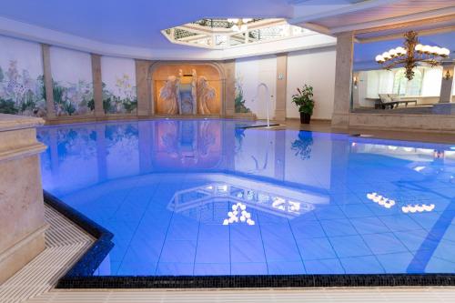 a large swimming pool in a building with a swimming pool at Romantik Berghotel Astenkrone in Winterberg