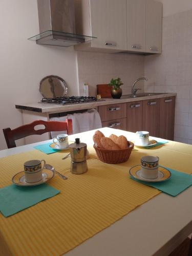 a kitchen with a table with a basket of bread on it at Appartamento Le Volte in Soleto