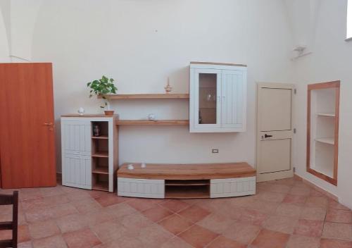 a kitchen with a bench and shelves in a room at Appartamento Le Volte in Soleto