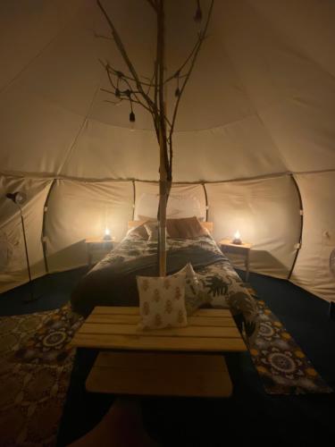 a bedroom with a tent with a bed and two candles at La Colmena Glamping in El Rosario