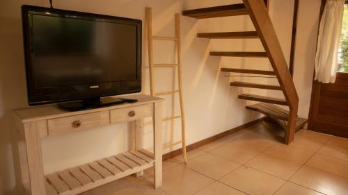 a television sitting on a table with a staircase at Cabañas Aire Fresco in Mar del Plata