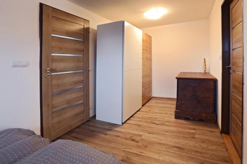 a bedroom with a door and a wooden floor at Chata Štrbian Telgárt s vírivkou v cene in Telgárt