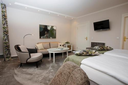 a bedroom with a bed and a living room at Romantik Berghotel Astenkrone in Winterberg