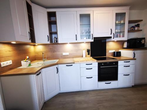 een keuken met witte kasten en een wastafel bij Kaiserhof auf Norderney in Norderney