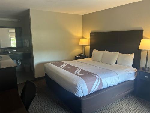 a hotel room with a large bed with white sheets at Quality Inn Mt Pleasant - Charleston in Charleston