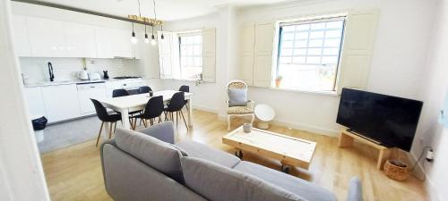 a living room with a couch and a table at Figueira Penthouse by the Marina in Figueira da Foz