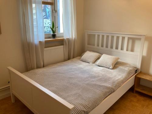 uma cama com duas almofadas num quarto com uma janela em Via Funghi, po prostu dom em Varsóvia