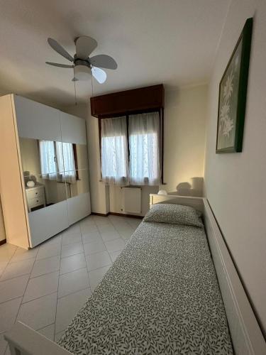 a bedroom with a bed and a ceiling fan at Lo scrigno in Chiozzola