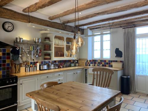 une cuisine avec une table en bois et quelques chaises dans l'établissement Sleeps 6 Vineyard Escape- PetsOK & Airport Access, à Saint-Méard-de-Gurçon
