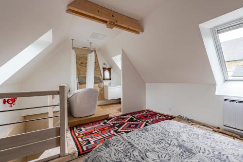 a attic bedroom with a bed and a bathroom at Les Jeux du Vent -Saint Jacut de la mer in Saint-Jacut-de-la-Mer