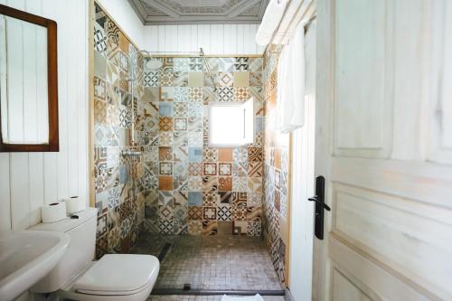 a bathroom with a toilet and a tiled wall at La Ferme Medina in Marrakesh