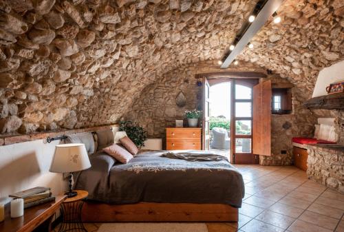 a bedroom with a bed and a stone wall at Rustico Bertel in San Zeno di Montagna