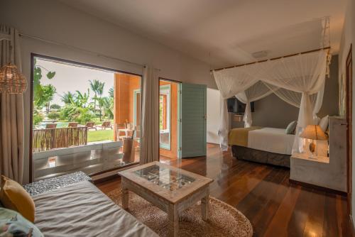 a bedroom with a bed and a bed and a table at Pousada Mi Secreto in São Miguel do Gostoso