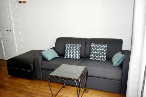 パリにあるCdH Lantiezのリビングルーム(黒いソファ、青い枕付)