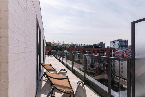 two chairs on a balcony with a view of a city at Le Se7t Penthouses in Montréal