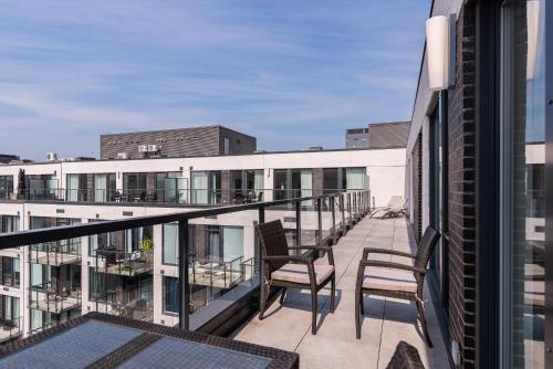 a balcony with chairs and tables on a building at Le Se7t Penthouses in Montréal