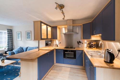 a kitchen with blue cabinets and a counter top at Oxfordshire Country Cottage in Wallingford
