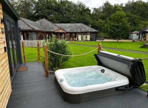 a hot tub on the deck of a house at Balmaha Lodges and Apartments in Balmaha