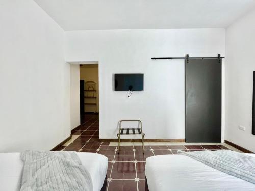 um quarto com duas camas e uma televisão na parede em Confortable Loft MN 960 B Centro Mty cerca de todo em Monterrey