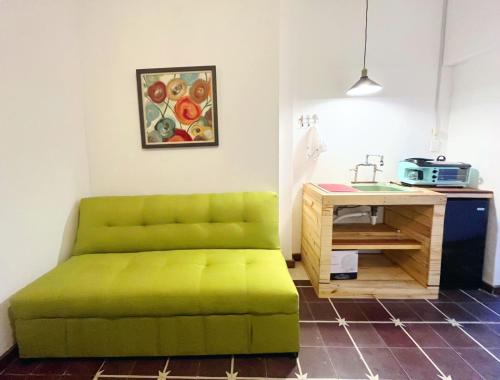 um sofá verde num quarto com uma mesa em Confortable Loft MN 960 B Centro Mty cerca de todo em Monterrey