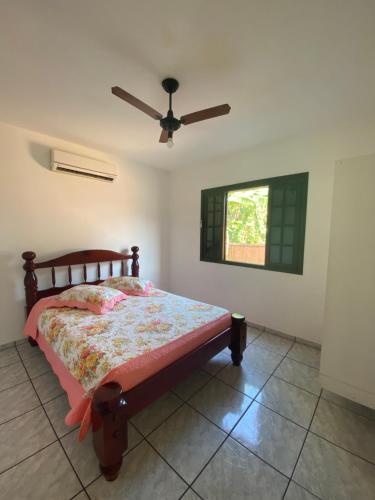 1 dormitorio con 1 cama y ventilador de techo en Chalés e suítes Lourenço, en Ilhabela