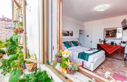 a bedroom with a bed and a room with plants at Sogna Venezia in Mestre