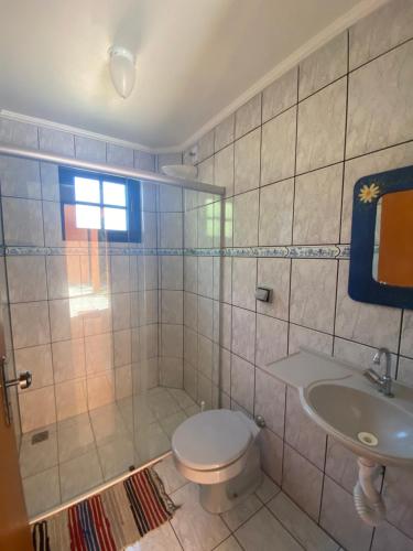a bathroom with a toilet and a sink at Chalés e suítes Lourenço in Ilhabela