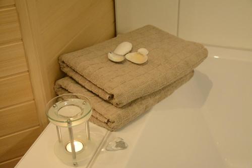 a bathroom with towels and a candle on a bath tub at Ferienwohnung OstseeBrise in Olpenitz