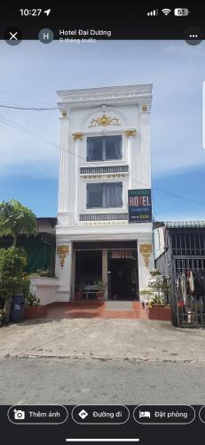 Thuan An的住宿－Hotel Đại Dương，白色的建筑,前面有标志