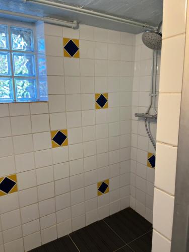 a bathroom with yellow and blue tiles on the wall at Camping Cote de Chevre 