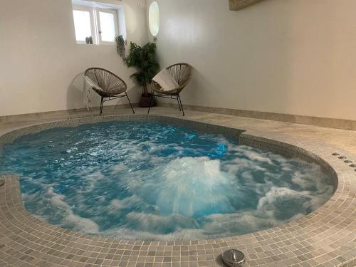 a large swimming pool with two chairs in a room at Le Jardin D'Elma in Vence