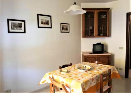 a dining room with a table and a television at L'Isola nel Mare in San Vito lo Capo