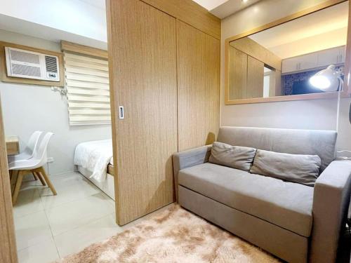 Habitación pequeña con sofá y dormitorio en Grass Residences 25th T5, en Manila