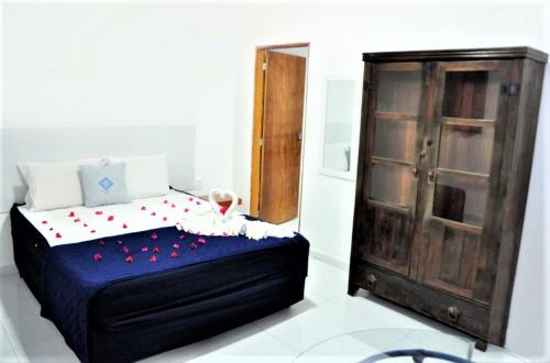 a bedroom with a bed and a wooden cabinet at La Suite Praia Hotel in Caucaia