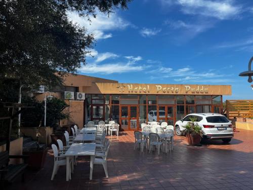 a group of tables and chairs in front of a building at Il Nido Dei Gabbiani in Palau